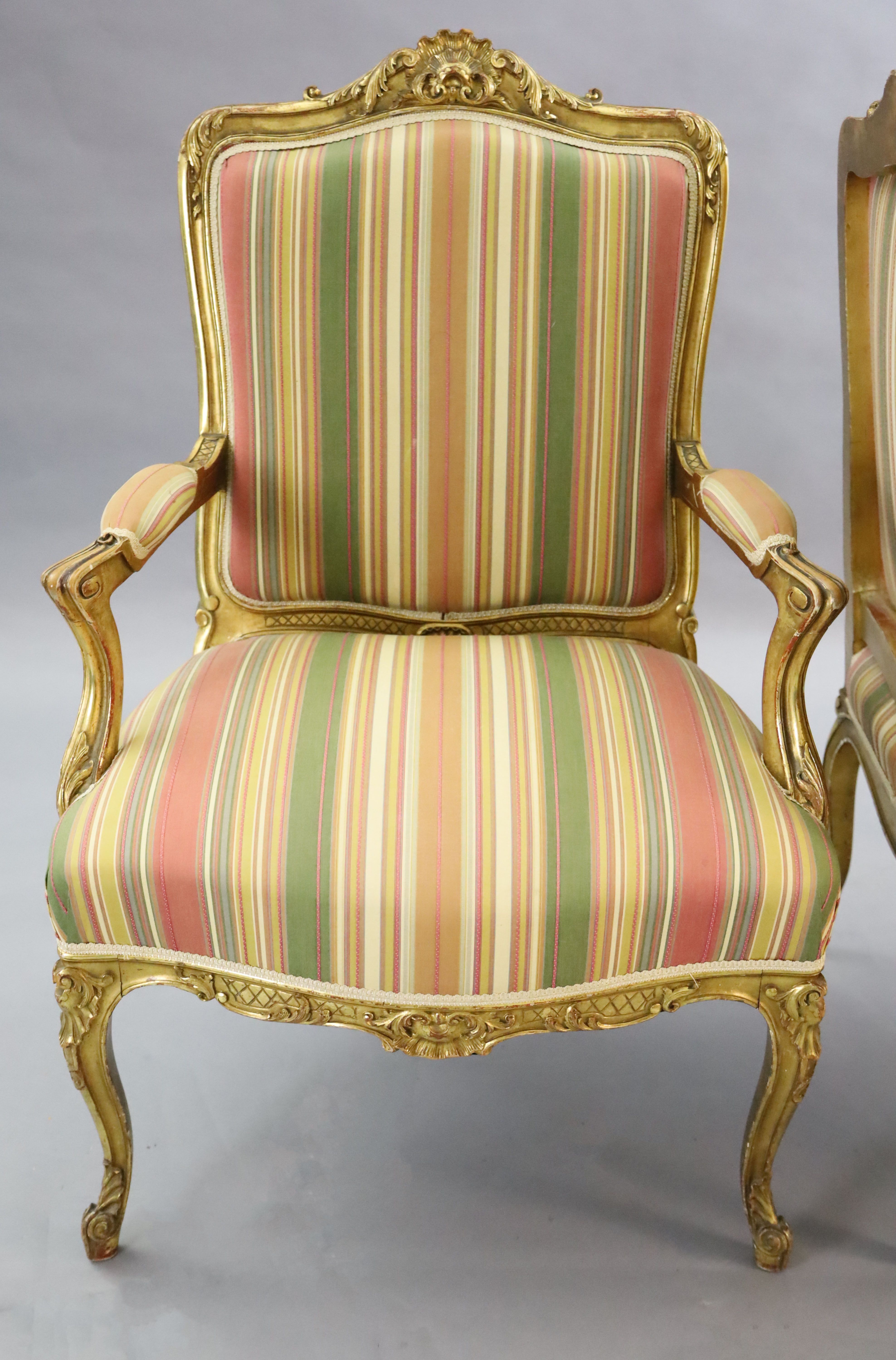 A pair of French gilt beech fauteuils, W.2ft 3in. D.2ft 1in. H.3ft 5in.